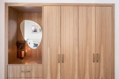 a wooden cabinet with a mirror in a room at Revel and Rest by Revelstoke Vacations in Revelstoke