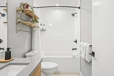 a white bathroom with a tub and a toilet at Skyridge Mountain Retreat 4BR with BBQ Near Banff in Canmore