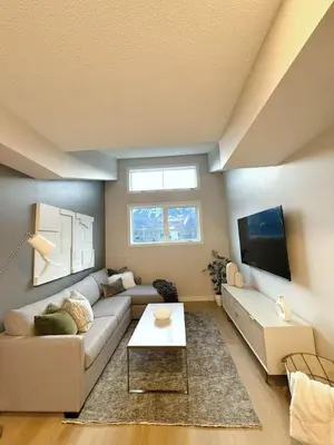 a living room with a couch and a tv at Mountain Retreat with Views and Hot Tub Near Banff Gates in Canmore