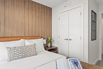 a bedroom with a white bed with a wooden headboard at Cozy 3BR Mountainside Haven Near Banff in Canmore