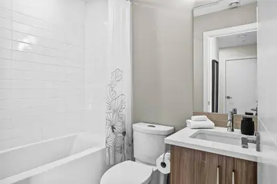 a bathroom with a toilet and a sink and a tub at 3BR Rockies Haven Near Banff with Private Patio in Canmore