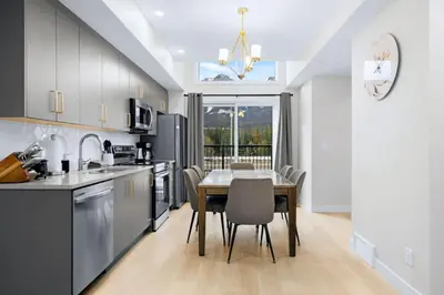 a kitchen and dining room with a table and chairs at Scenic 3BR Townhouse with Mountain Views Near Banff in Canmore