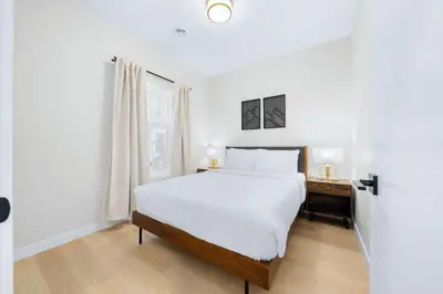 a white bedroom with a large bed and a desk at Scenic 3BR Townhouse with Mountain Views Near Banff in Canmore
