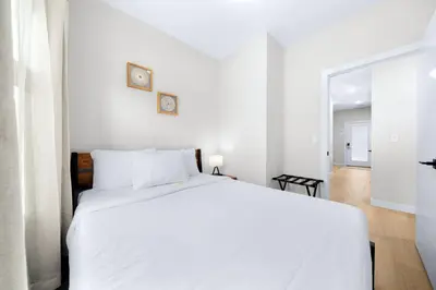 a white bedroom with a white bed and a mirror at Scenic 3BR Townhouse with Mountain Views Near Banff in Canmore