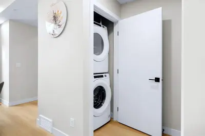 a white laundry room with a washer and dryer at Scenic 3BR Townhouse with Mountain Views Near Banff in Canmore
