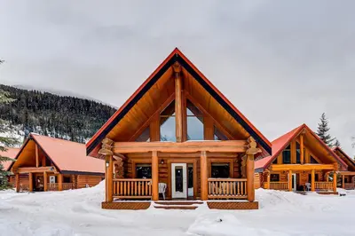 a log cabin with snow on the ground at Beautiful Cottage In The Heart Of The Rockies in Golden