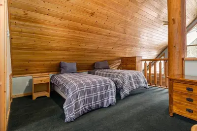 a bedroom with two beds in a wooden cabin at Beautiful Cottage In The Heart Of The Rockies in Golden