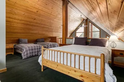 a bedroom with two beds in a log cabin at Beautiful Cottage In The Heart Of The Rockies in Golden