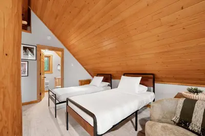 two beds in a room with a wooden ceiling at Rustic Cabin Hideaway with BBQ Fire Pit and Mtn Views in Golden