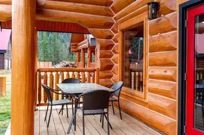 a wooden deck with a table and chairs on it at Rustic Cabin Hideaway with BBQ Fire Pit and Mtn Views in Golden