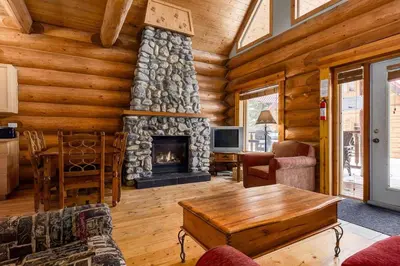 a living room with a fireplace in a log cabin at Wonderful Rockies Cabin Getaway for Hike or Ski in Golden