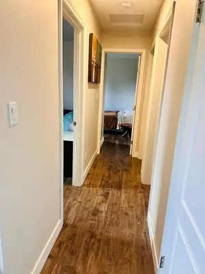 a hallway leading to a bedroom with a hard wood floor at Mountain Joy Getaway in Valemount