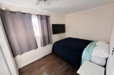 a small bedroom with a bed and a television at Mountain Joy Getaway in Valemount