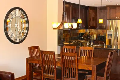 a kitchen with a table and chairs and a clock on the wall at Luxury Canmore Vacations in Canmore