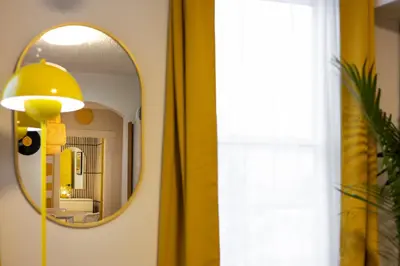 a mirror in a room with a yellow lamp at Quiet Yellow Unit- Stampede, BMO, Nightlife Etc. in Calgary
