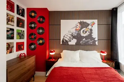 a bedroom with a red wall with a bed and records at Retro-Chic Hideaway - Walking Distance To Stampede in Calgary