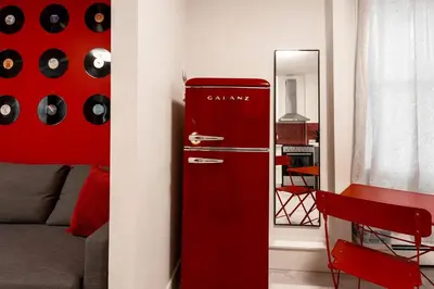 an old red refrigerator in a living room at Retro-Chic Hideaway - Walking Distance To Stampede in Calgary