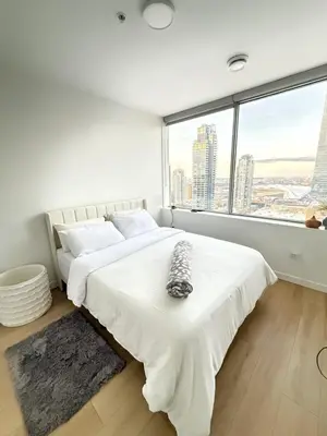 a bedroom with a large white bed with a large window at Luxury Downtown One Bedroom with Skyline Views and Free Parking in Edmonton