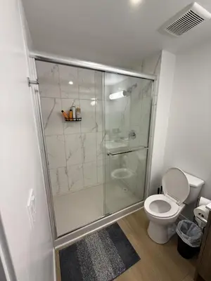 a bathroom with a shower and a toilet at Luxury Downtown One Bedroom with Skyline Views and Free Parking in Edmonton