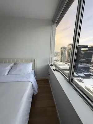a bedroom with a bed and a large window at Luxury Downtown One Bedroom with Skyline Views and Free Parking in Edmonton