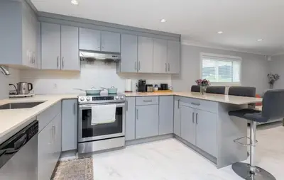 a kitchen with white cabinets and a counter top at Large 3 Bedroom Laneway House in Vancouver