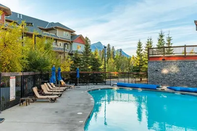a swimming pool with lounge chairs and a resort at Heated Outdoor Pool Near Banff Park in Canmore