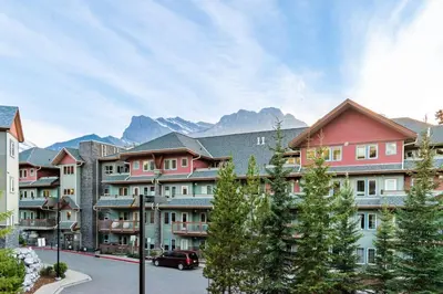 a group of buildings with mountains in the background at Heated Outdoor Pool Near Banff Park in Canmore