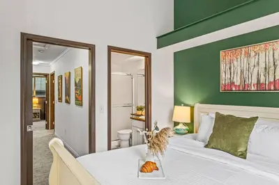a bedroom with a large bed with a green wall at Stylish Mountain Retreat 2BR Chalet and Hot Pool in Canmore