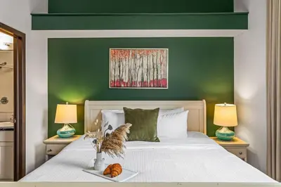 a bedroom with a bed with a green wall at Stylish Mountain Retreat 2BR Chalet and Hot Pool in Canmore