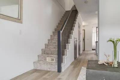 a staircase in a home with white walls and wood floors at Stylish Mountain Retreat 2BR Chalet and Hot Pool in Canmore
