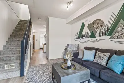 a living room with a couch and a staircase at Stylish Mountain Retreat 2BR Chalet and Hot Pool in Canmore