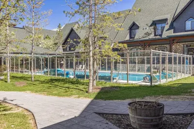 a house with a swimming pool in a glass house at Stylish Mountain Retreat 2BR Chalet and Hot Pool in Canmore