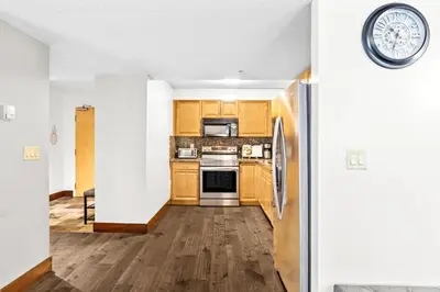 a kitchen with wooden cabinets and stainless steel appliances at 2BR MTN Canmore Retreat with Private Balcony in Canmore