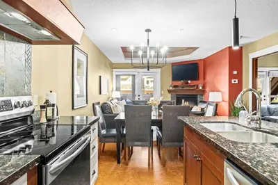 a kitchen and dining room with a table and chairs at Serene 2BR Solara Escape with BBQ Pool and Hot Tub in Canmore