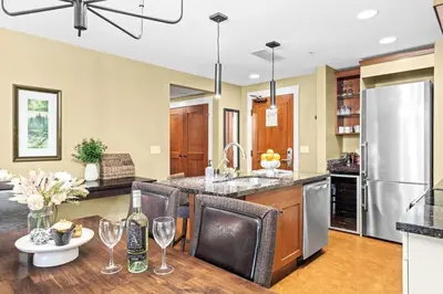 a kitchen with a table with wine glasses on it at Serene 2BR Solara Escape with BBQ Pool and Hot Tub in Canmore