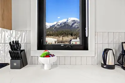 a kitchen with a window with a bowl of fruit at 3BR Rockies Have Sleeps 8 with Hot Tub Pool and Mtn Views in Canmore