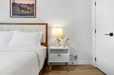 a bedroom with a bed and a nightstand with a lamp at 3BR Rockies Have Sleeps 8 with Hot Tub Pool and Mtn Views in Canmore