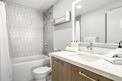 a bathroom with a sink and a toilet and a tub at 3BR Rockies Have Sleeps 8 with Hot Tub Pool and Mtn Views in Canmore