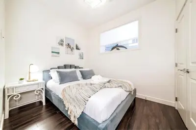 a white bedroom with a bed and a window at 3BDRM Winter Haven - King Beds - Fireplace - Garage in Edmonton