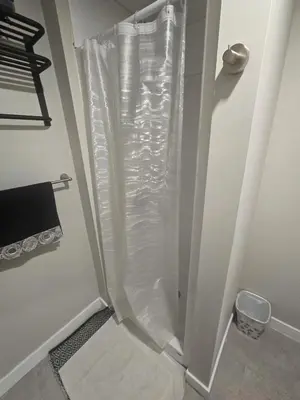 a shower with a plastic shower curtain in a bathroom at Beautiful Serenity in Edmonton