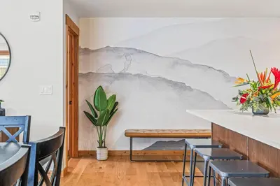 a wall mural in a dining room with a bench at Luxury 1750sf Condo In DT Canmore Sleeps 10 in Canmore