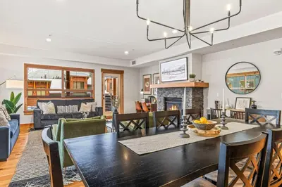 a dining room and living room with a table and chairs at Luxury 1750sf Condo In DT Canmore Sleeps 10 in Canmore