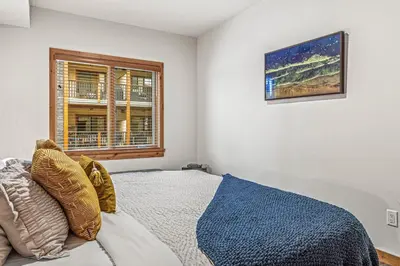 a bedroom with a bed and a window at Luxury 1750sf Condo In DT Canmore Sleeps 10 in Canmore