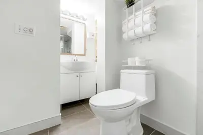 a white bathroom with a toilet and a sink at BudgetWise Semi-Basement near Airport, UBC, Downtown in Vancouver in Vancouver