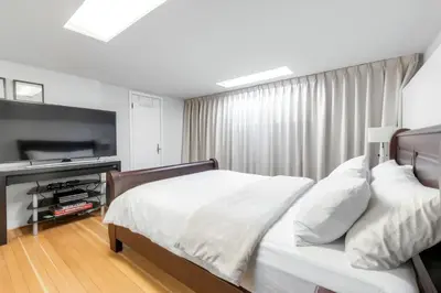 a bedroom with a bed and a flat screen tv at BudgetWise Semi-Basement near Airport, UBC, Downtown in Vancouver in Vancouver