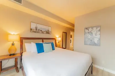 a bedroom with a large bed with blue pillows at Corner Mountain View Retreat 2 Kings w Patio in Canmore
