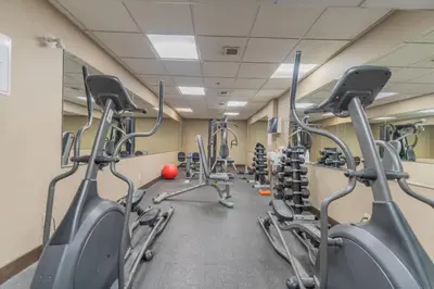 a gym with rows of cardio bikes and treadmills at Corner Mountain View Retreat 2 Kings w Patio in Canmore