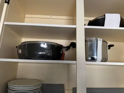 a kitchen pantry with a pot and dishes on shelves at Fully furnished House near GrayNuns, Millwoods in Edmonton