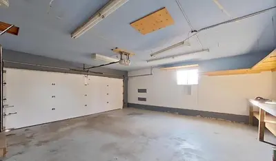 an empty garage with white walls and white doors at Fully furnished House near GrayNuns, Millwoods in Edmonton