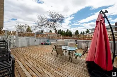 a patio with a table and chairs on a wooden deck at All what you need in a House near GrayNuns, Millwoods in Edmonton